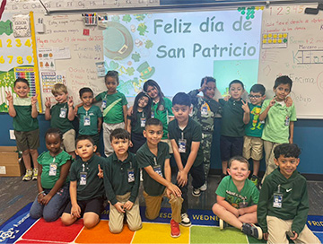 Classroom of happy elementary students celebrating Feliz Día de San Patricio