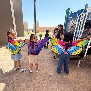 Three girls outside wearing butterfly costumes
