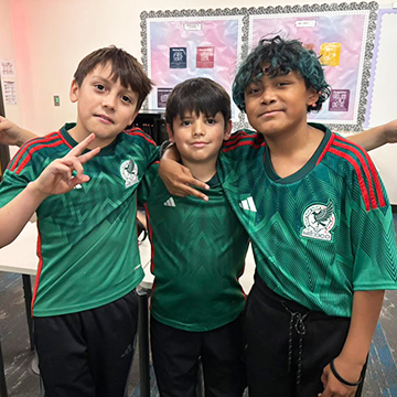 Three boys in green soccer shirts