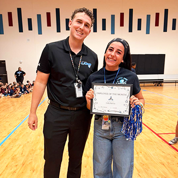 Two staff members posing for a picture in the school gym