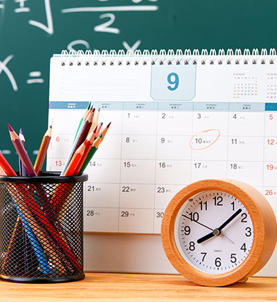 A calendar on a desk with a clock