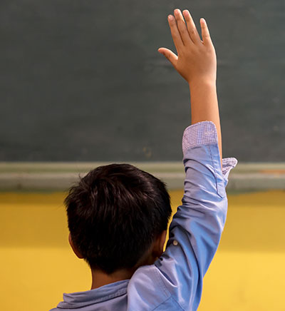 Student raising his hand in class