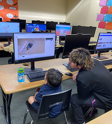 two students watching a computer screen