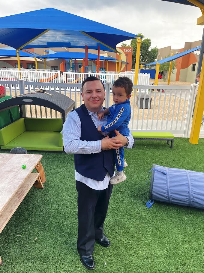Director Vincent Medina holding a child on the playground
