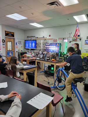 Student running a bicycle to create electricity