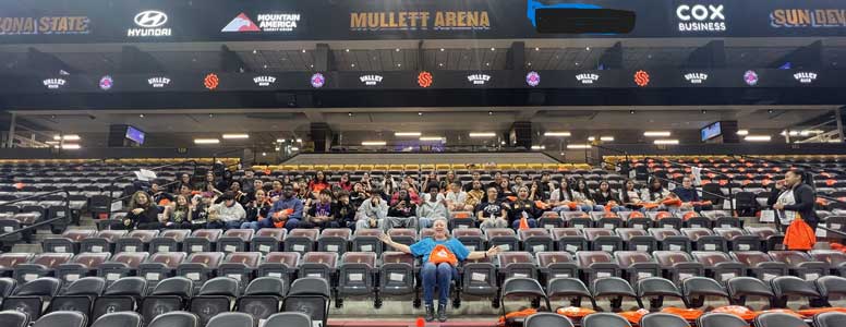 Students and staff sitting in arena seats