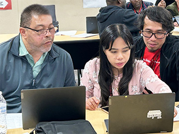 Adult and student working with laptops