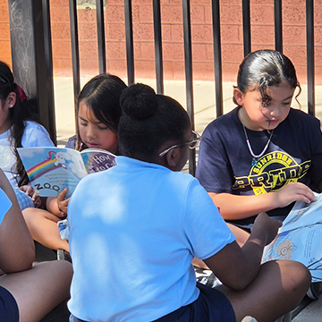 Group of students enjoying reading outside