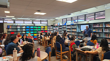 Staff sitting in the library listening to a presentation