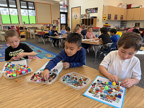 Three students at a table counting items