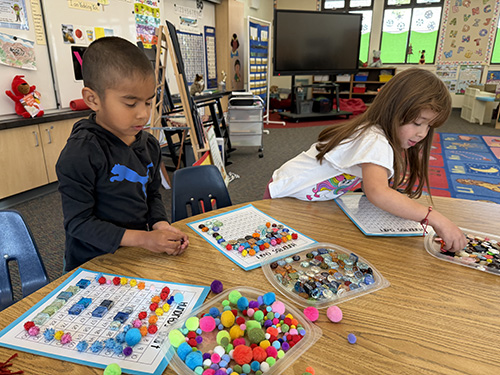 Two students counting 100 day items at their desks