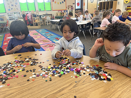Three students focused on a button activity
