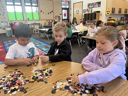 Three students working on a button activity together