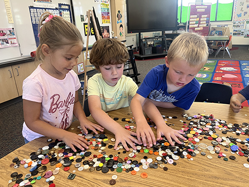 Group of Mrs. Thomason’s TK students working with colorful buttons at a table