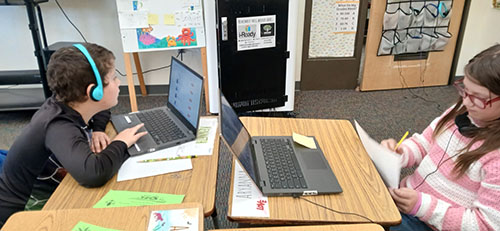 Third graders working with laptops in the classroom