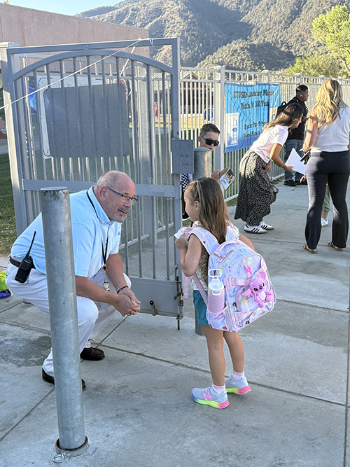 Principal welcoming a student on the first day of school