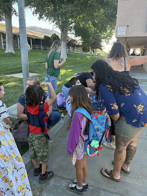 Parents saying goodbye to children on first day of school