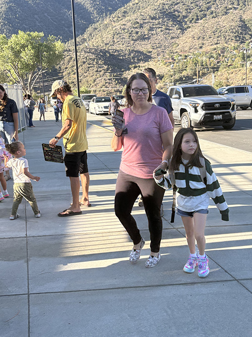 Parent walking and holding hands with her student