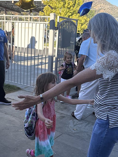 Student walking to give a woman a hug