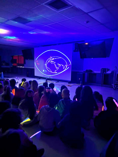 Students enjoying assembly presented by Prismatic Laser