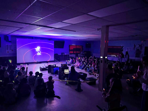 Students enjoying assembly presented by Prismatic Laser