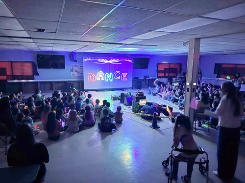 Students sitting on the floor to watch show