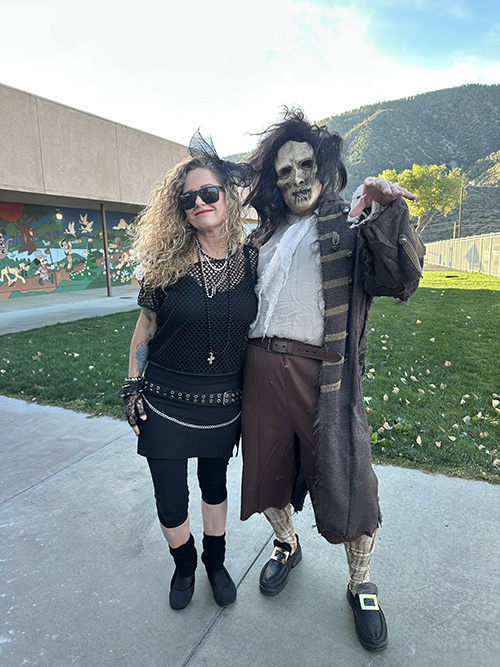 Two staff members dressed up for Halloween outside on the school campus