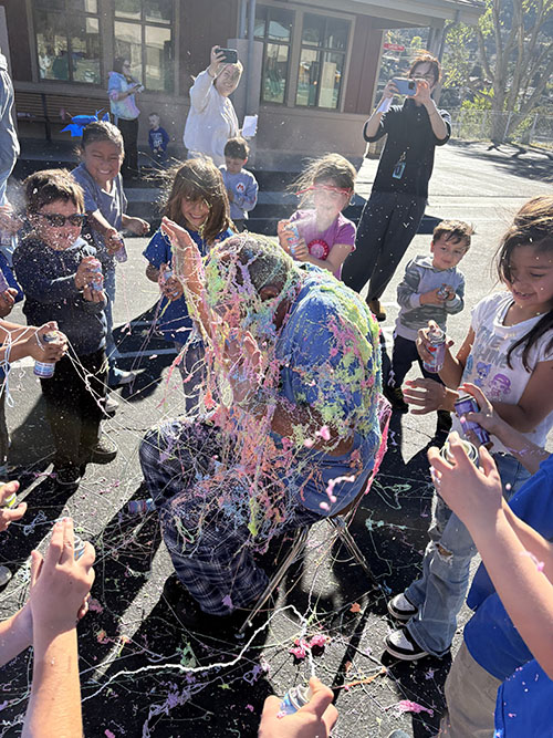 Attendance winners spraying Silly String on principal