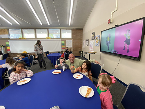Principal posing for with a group of students during perfect attendance award event