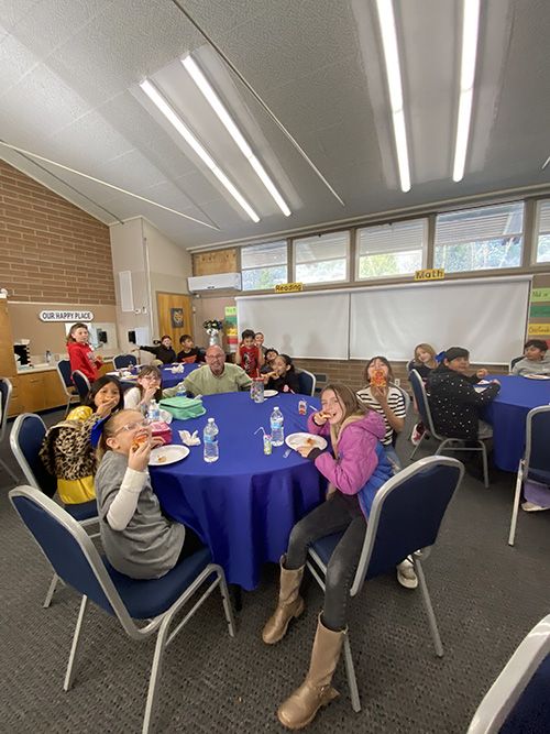 Student sitting with the principal during perfect attendance reward event