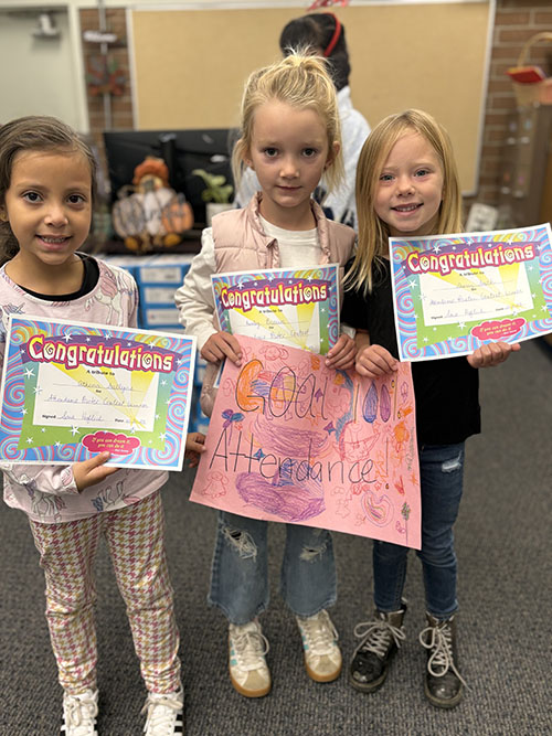 Three students posing with their award certificates