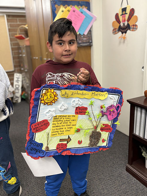 Student holding up his creative poster