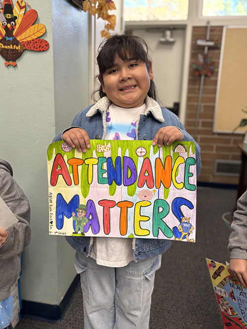 Student holding her colorful attendance matters poster