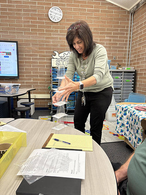 Teacher having fun balancing objects on a table