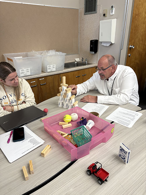 Principal and teacher engaged in learning a new STEAM activity