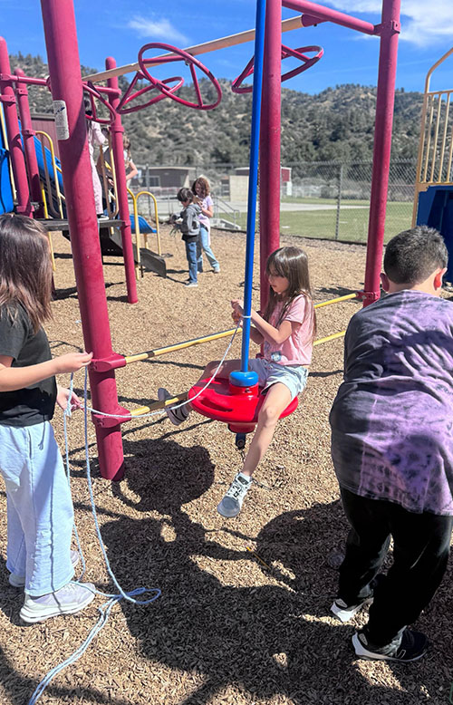 Third grade students on the playground doing an experiment