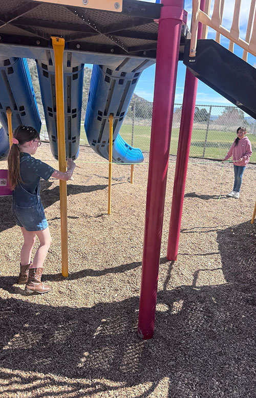 Two third graders in Mrs. Page’s class outside working on a project