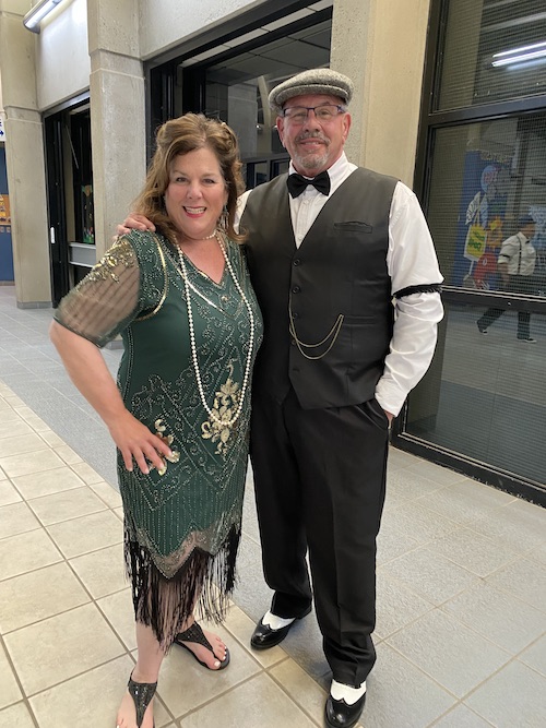 Principal posing for a picture with a woman in a pretty green dress