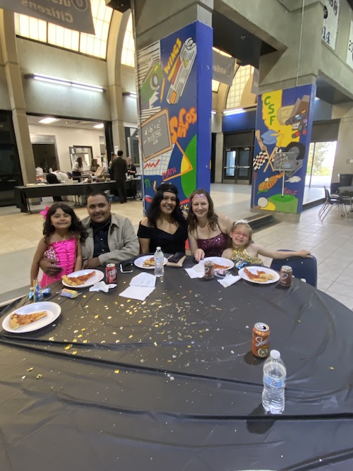 Group of adults and students enjoying pizza at the ball