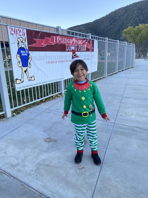 Student elf in green posing for a picture