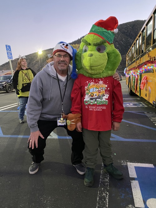 Principal posing for a picture with the Grinch