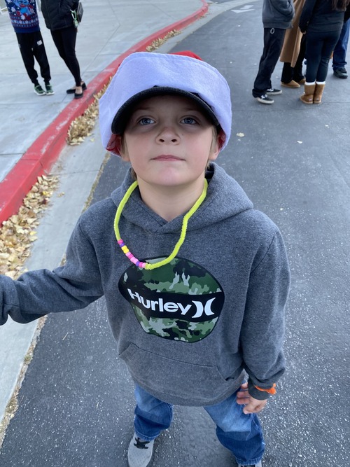 Student in a Santa hat looking up at the camera