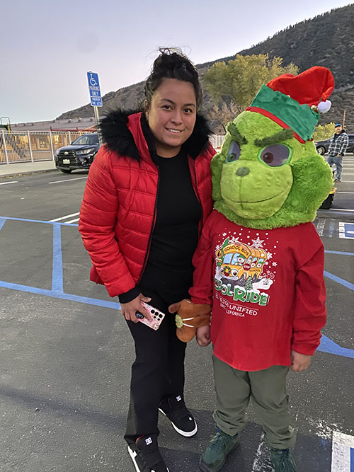 Woman next to a student dressed as the Grinch