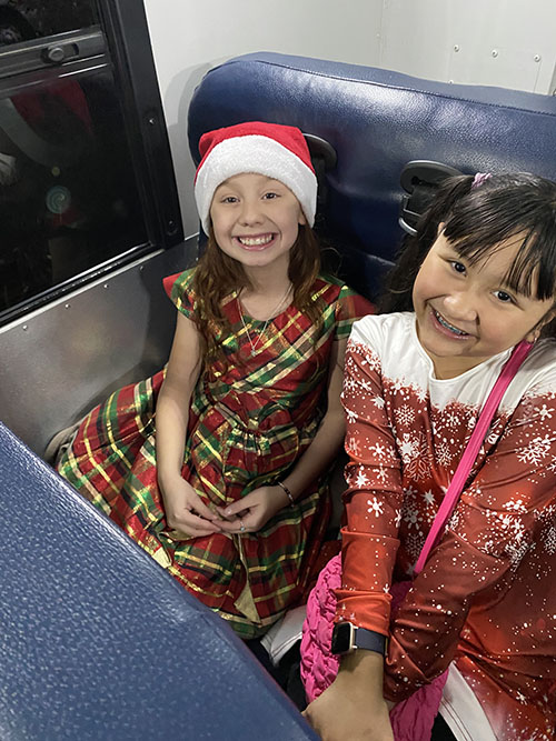 Two happy girls sitting and smiling for the camera