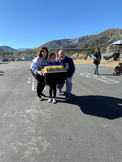 Student and teachers carrying a box