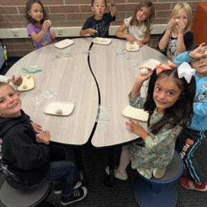 Group of children playing with modeling clay at a school table
