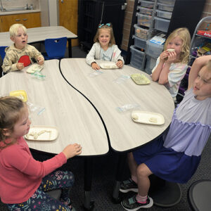 Young students sitting around a table molding clay