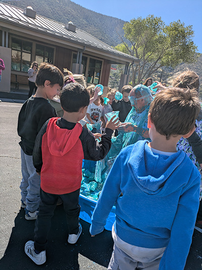 Another view of children pouring slime on Principal McNelis
