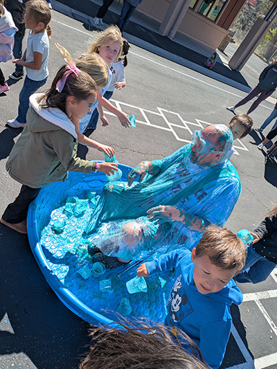 Children with cups of slime to pour on Principal McNelis