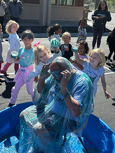 Children pouring slime on Principal McNelis' head